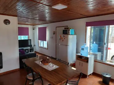a living room with a table and a refrigerator at La soñada in San Antonio de Arredondo