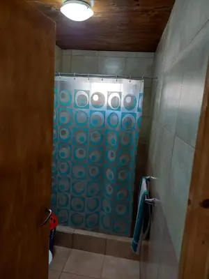 a bathroom with a shower with a blue shower curtain at La soñada in San Antonio de Arredondo