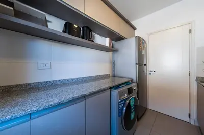 a small kitchen with a washing machine in it at Viaggiato Jacinto Rios in Cordoba