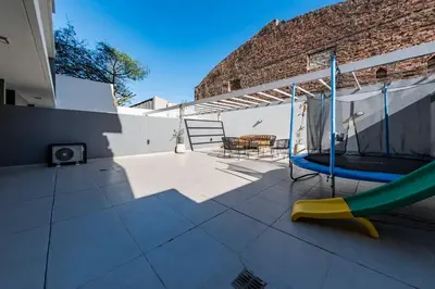 a patio with a slide and a table and chairs at Viaggiato Jacinto Rios in Cordoba