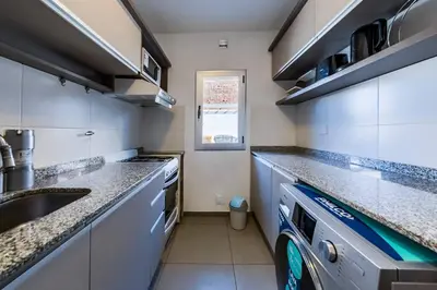 a kitchen with granite counter tops and a sink at Viaggiato Jacinto Rios in Cordoba