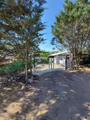 a shelter with a tree and a fence at Hermosa casa con pileta en estancia vieja carlos paz in Estancia Vieja