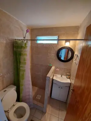 a bathroom with a toilet and a sink and a mirror at Hermosa casa con pileta en estancia vieja carlos paz in Estancia Vieja
