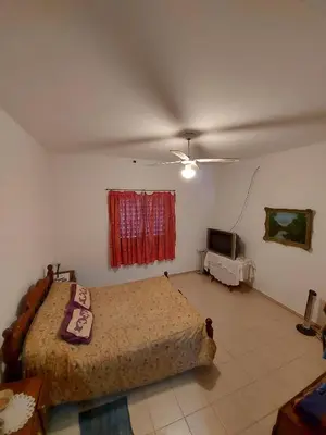 a bedroom with a large bed and a television at Hermosa casa con pileta en estancia vieja carlos paz in Estancia Vieja
