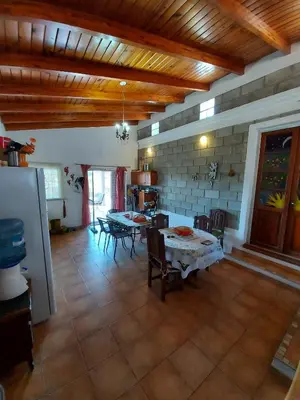 a living room with a table and chairs in it at Hermosa casa con pileta en estancia vieja carlos paz in Estancia Vieja