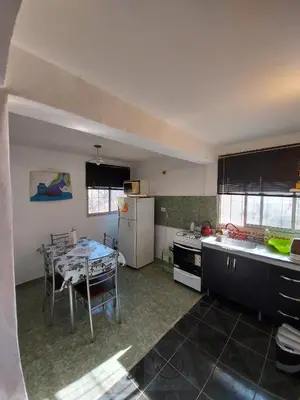 a kitchen with a table and a refrigerator and a table and a table at Hermosa casa con pileta en estancia vieja carlos paz in Estancia Vieja