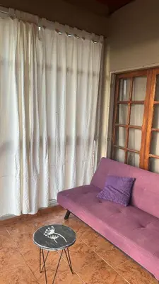 a purple couch in a living room with a table at Montecielo in San Antonio de Arredondo