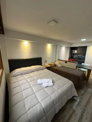 a bedroom with a large bed with a white blanket at Departamento amoblado con Amenities 104 INVERHOME INMOBILIARIA in Cordoba
