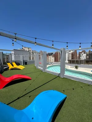 a rooftop patio with a pool and green grass at Departamento amoblado con Amenities 104 INVERHOME INMOBILIARIA in Cordoba