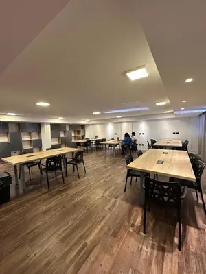 a room with tables and chairs and people in the background at Departamento amoblado con amenities 106 INVERHOME INMOBILIARIA in Cordoba