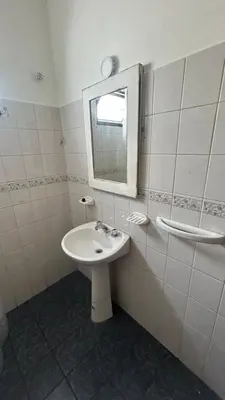 a white bathroom with a sink and a mirror at 760 C Apartamentos in Alta Gracia