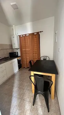 a kitchen with a black table and a black chair at 760 C Apartamentos in Alta Gracia