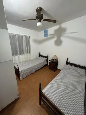 a bedroom with two beds and a ceiling fan at La Colina - Cosquín in Cosquín