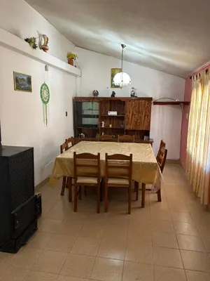 a dining room with a table and chairs and a television at La Colina - Cosquín in Cosquín