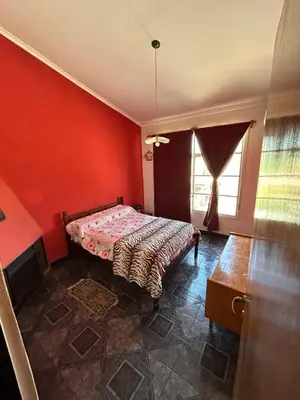 a bedroom with a bed and a red wall at La Colina - Cosquín in Cosquín