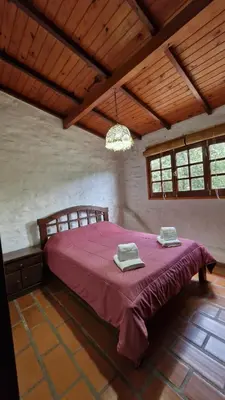 a bedroom with a large bed with a purple blanket at Lucía Haus in Villa General Belgrano