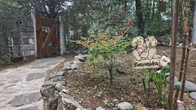 a sign in a garden next to a door at Lucía Haus in Villa General Belgrano