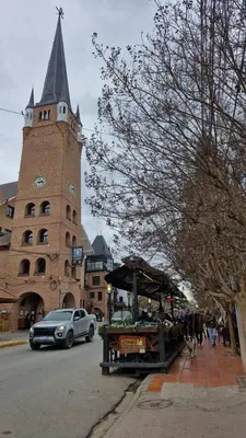 a building with a clock tower with a market on the street at Lucía Haus in Villa General Belgrano