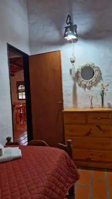a bedroom with a bed and a dresser and a mirror at Lucía Haus in Villa General Belgrano