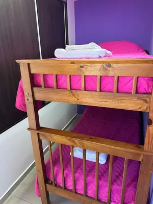 a bunk bed with pink sheets on top of it at Miralejos 17 in Villa Carlos Paz