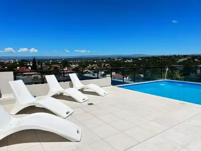 a group of white chairs sitting on top of a building at Miralejos 17 in Villa Carlos Paz