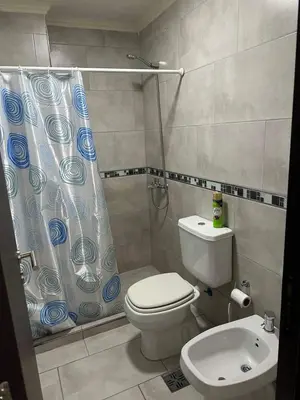 a bathroom with a toilet and a shower curtain at Miralejos 17 in Villa Carlos Paz