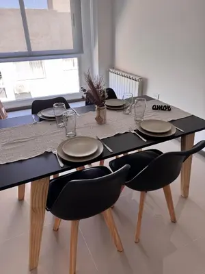 a dining room table with chairs and plates on it at Departamento Moderno Céntrico in Villa Carlos Paz
