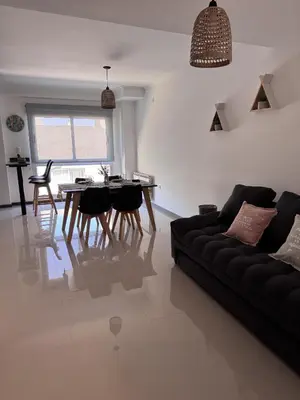 a living room with a black couch and a table at Departamento Moderno Céntrico in Villa Carlos Paz