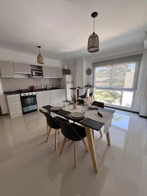 a kitchen and dining room with a table and chairs at Departamento Moderno Céntrico in Villa Carlos Paz