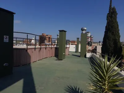 a balcony of a building with a fence and a tree at Dpto Tempo Carlos Paz in Villa Carlos Paz