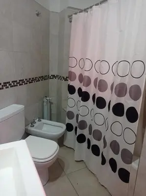 a bathroom with a toilet and a shower curtain at Dpto Tempo Carlos Paz in Villa Carlos Paz