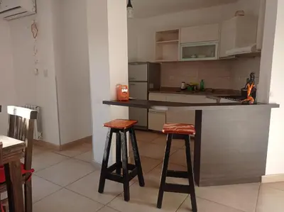 a kitchen with two bar stools and a counter at Dpto Tempo Carlos Paz in Villa Carlos Paz