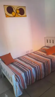 a bed in a room with a blanket on it at Dpto Tempo Carlos Paz in Villa Carlos Paz