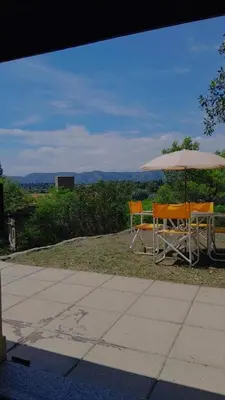 a table and chairs under an umbrella with a view at Chalet Doña Ines in Cuesta Blanca
