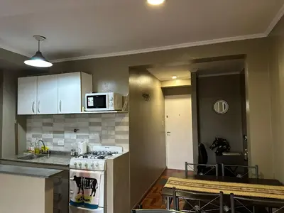 a kitchen with a stove and a counter top at Departamento frente a la Ciudad Universitaria in Cordoba