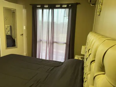 a bedroom with a bed and a window at Departamento frente a la Ciudad Universitaria in Cordoba