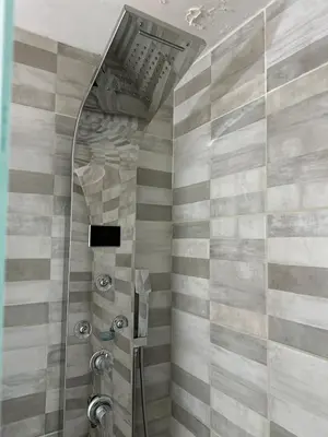 a bathroom with a shower with gray and white stripes at Departamento frente a la Ciudad Universitaria in Cordoba