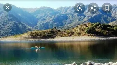 a person in a boat on a body of water at Cabaña los Lechusos in Cortaderas