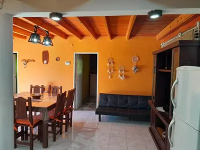 a kitchen and dining room with a table and chairs at Cabaña los Lechusos in Cortaderas