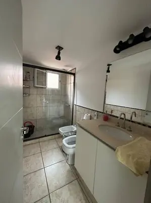 a bathroom with a toilet and a sink and a mirror at Departamento espacioso en un complejo residencial, cerca del Shopping nuevo centro in Cordoba