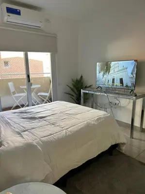 a bedroom with a bed and a flat screen tv at Departamento espacioso en un complejo residencial, cerca del Shopping nuevo centro in Cordoba