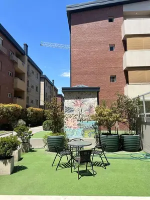 a patio with a table and chairs in front of a building at Departamento espacioso en un complejo residencial, cerca del Shopping nuevo centro in Cordoba