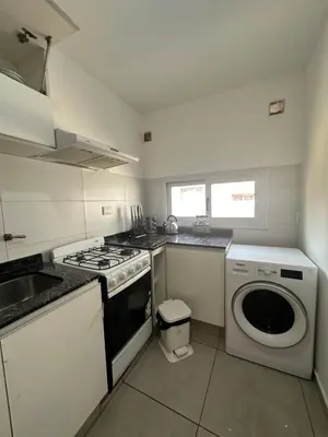 a kitchen with a stove and a washing machine at Departamento espacioso en un complejo residencial, cerca del Shopping nuevo centro in Cordoba