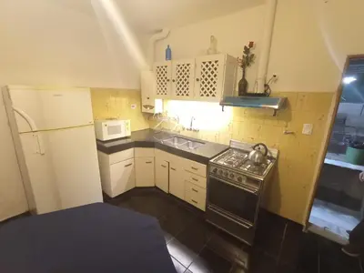 a small kitchen with a stove and a microwave at Casa Tupungato in Villa Carlos Paz