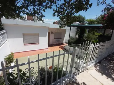 a white fence in front of a white house at Casa Tupungato in Villa Carlos Paz
