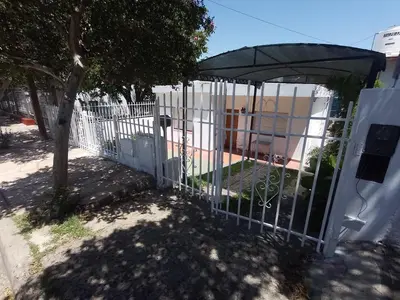 a white gate with a tree behind it at Casa Tupungato in Villa Carlos Paz