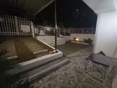 a patio at night with a bench and a fence at Casa Tupungato in Villa Carlos Paz