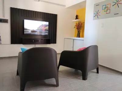 a living room with two chairs and a television at Casa Yowen in Mina Clavero