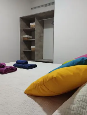 a yellow pillow sitting on a bed with two towels at Casa Yowen in Mina Clavero