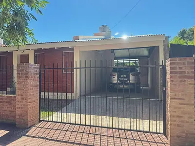 a house with a gate with a car in the garage at Casa Yowen in Mina Clavero